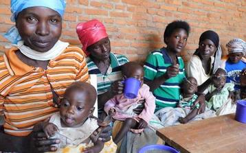 Mutter mit Kindern in Burundi bei der Ausgabe im Ernährungszentrum